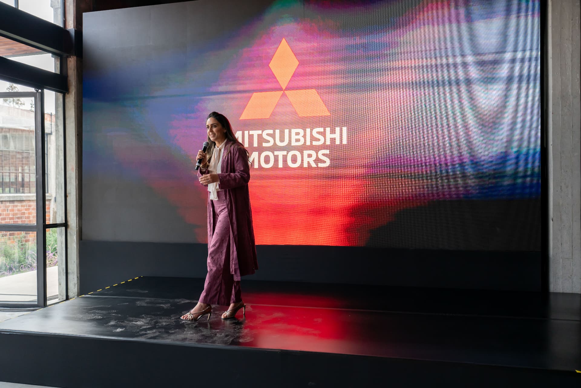 Conducción de la ceremonia frente a la pantalla Mitsubishi Motors