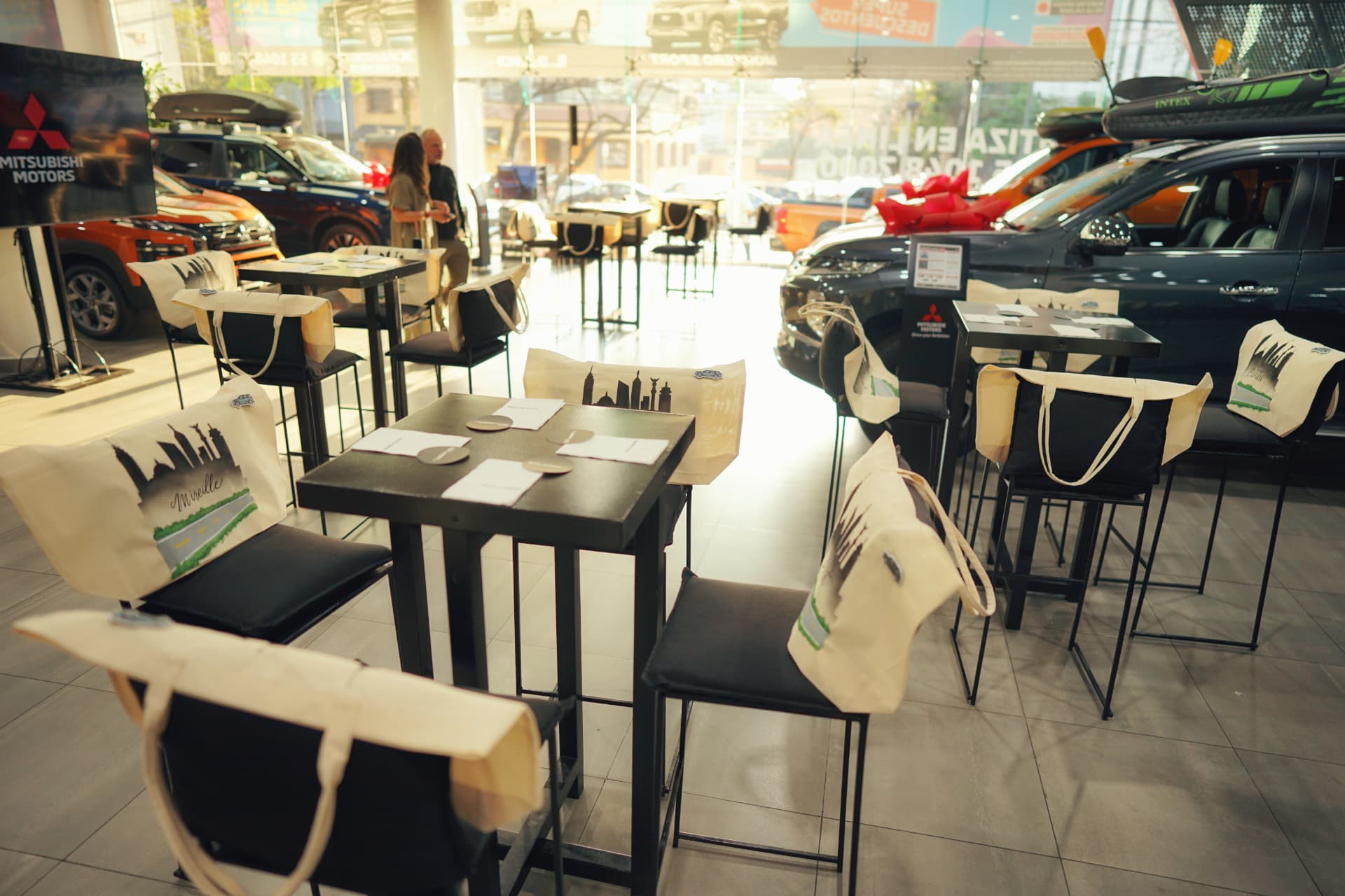 Showroom Mitsubishi con mesas y tote bags de bienvenida