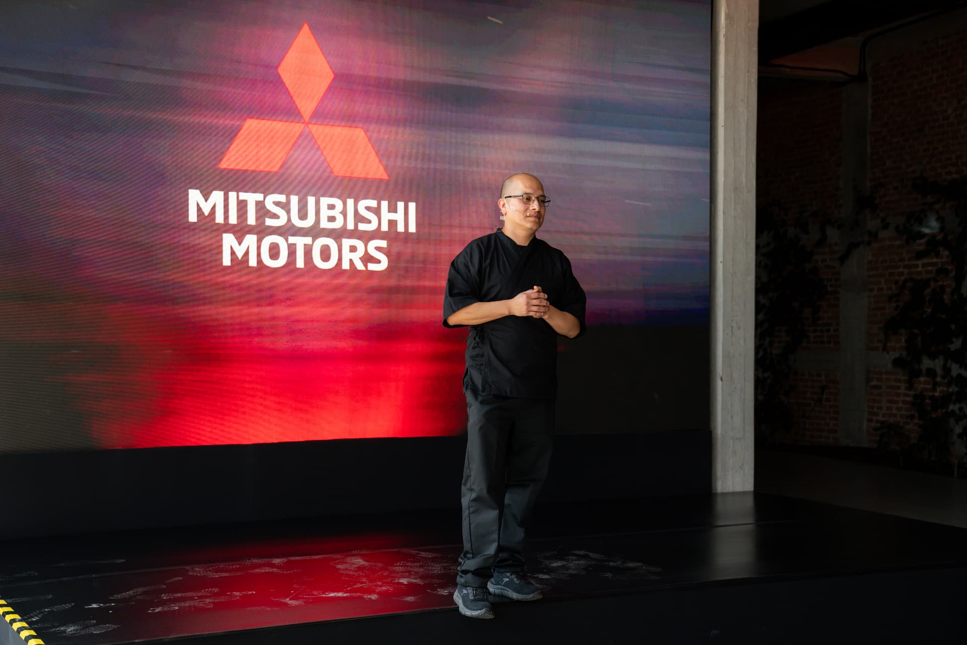 Chef presentando el menú frente a la pantalla Mitsubishi