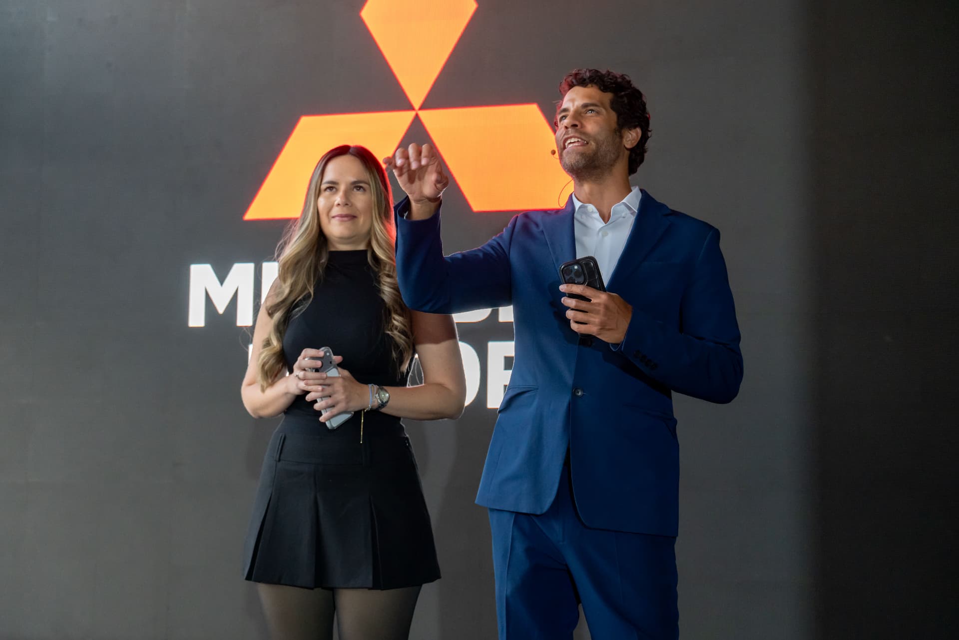 Conducción con la vocera de marca frente al logo Mitsubishi