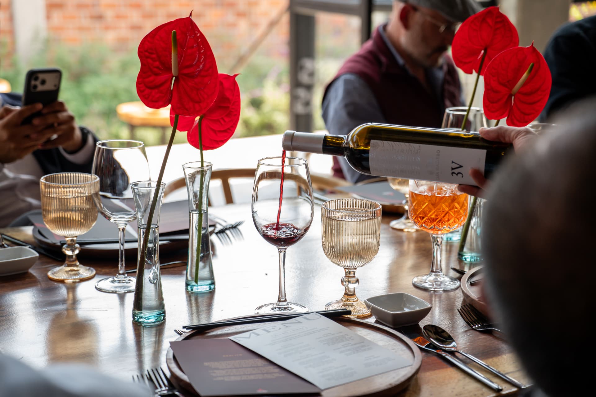 Servicio de vino en la mesa con anturios