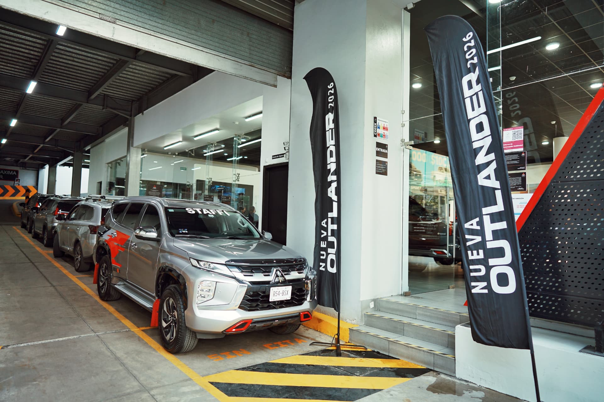 Flota Outlander 2026 con banners de lanzamiento en el acceso